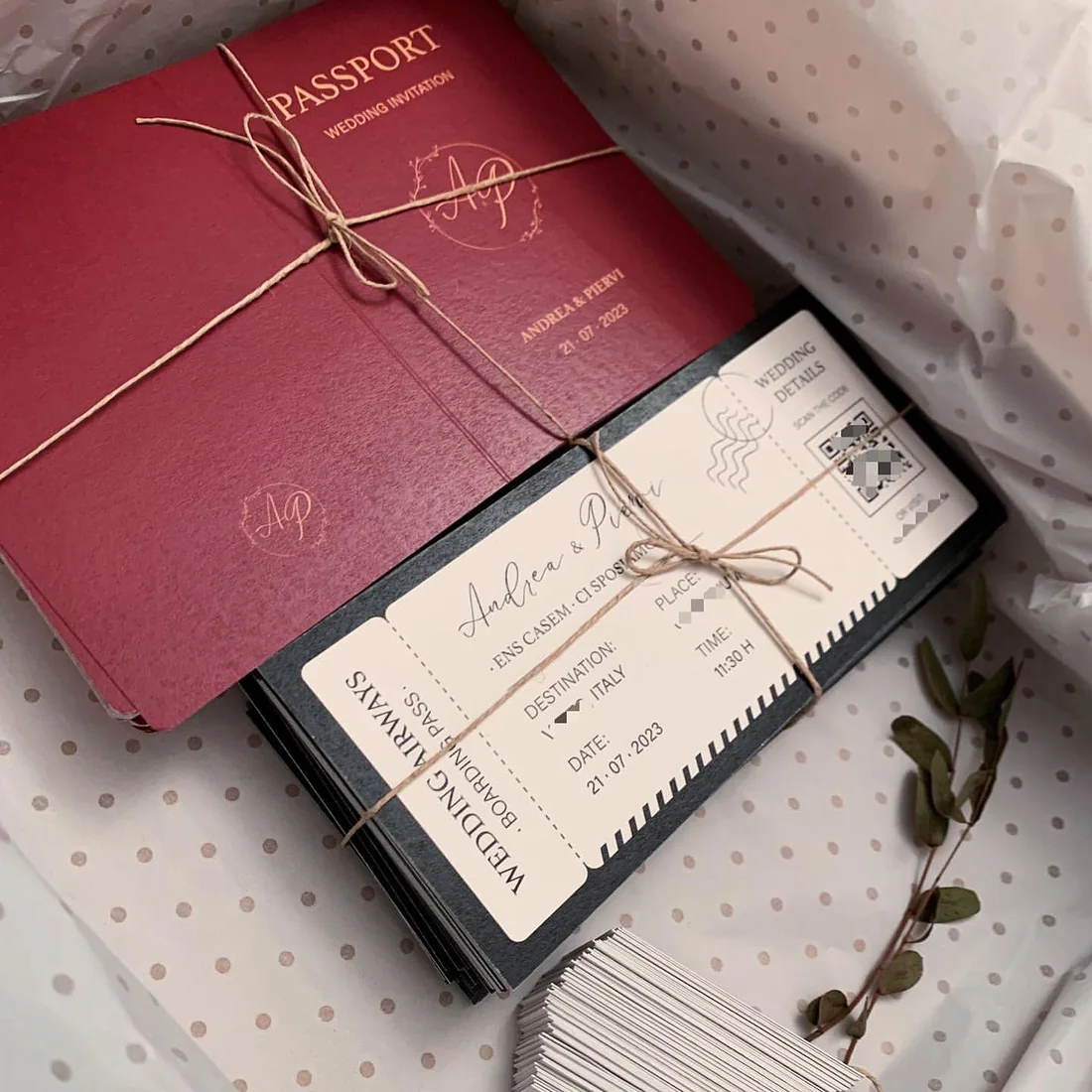 Burgundy passport wedding invitation tied to a boarding-pass insert