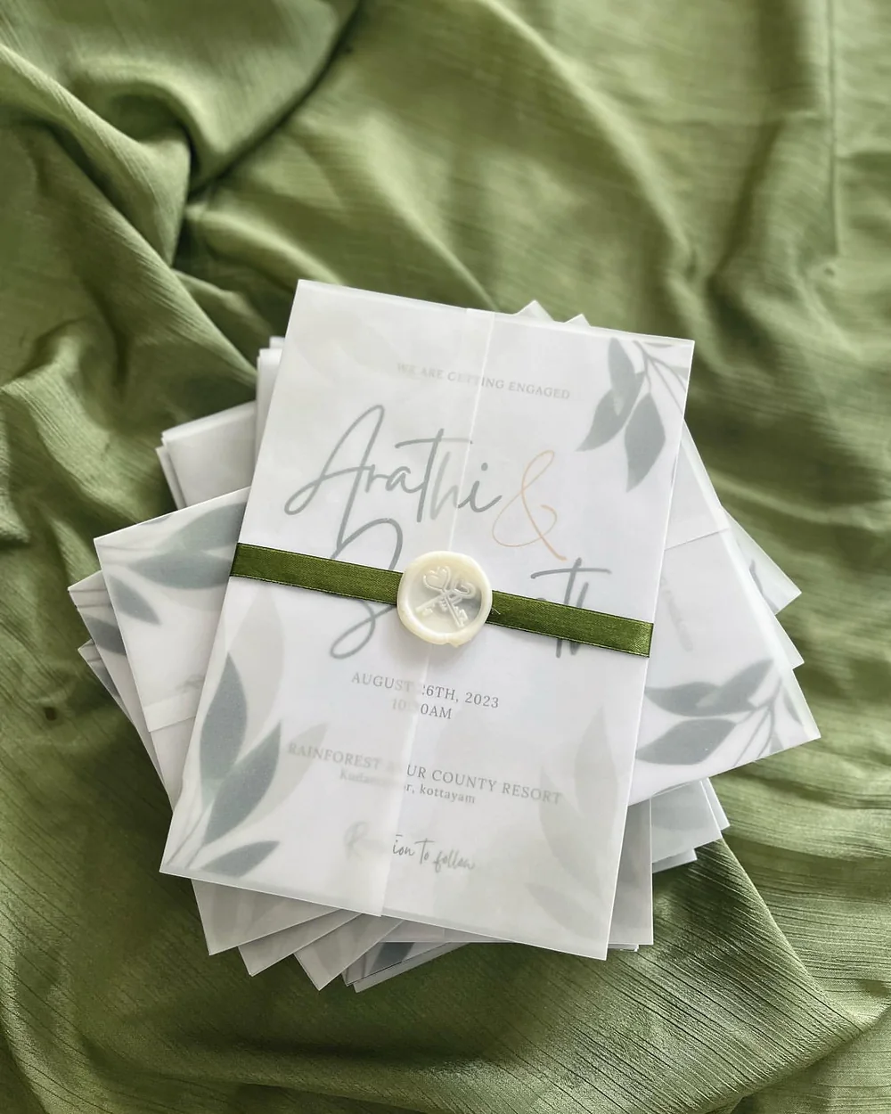 Leaf-print vellum wrap with olive ribbon and wax seal
